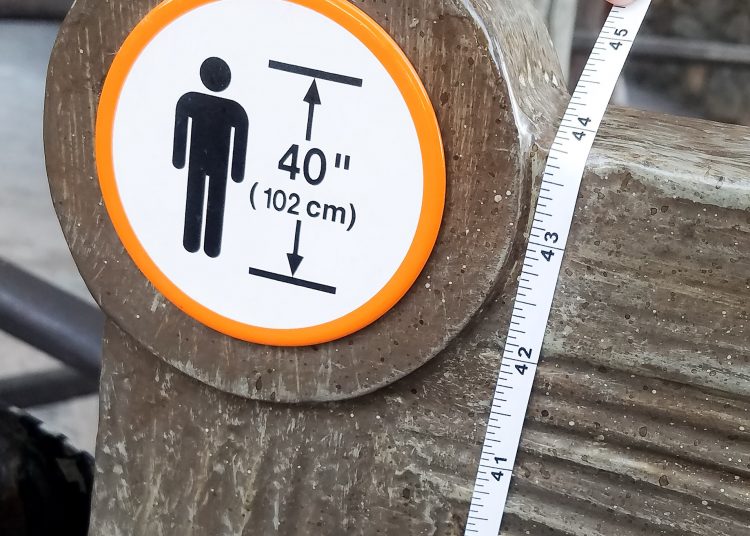Disneyland height requirement marker showing 40 inches with a tape measure to check accuracy
